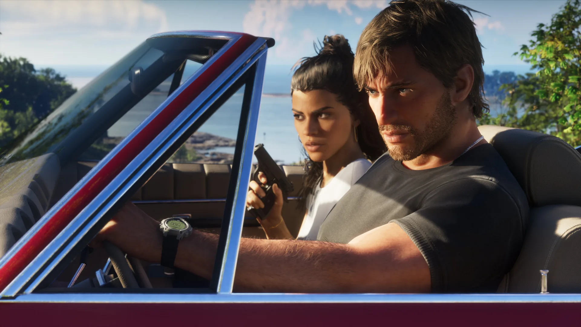 Two people riding together in a red convertible by the coast