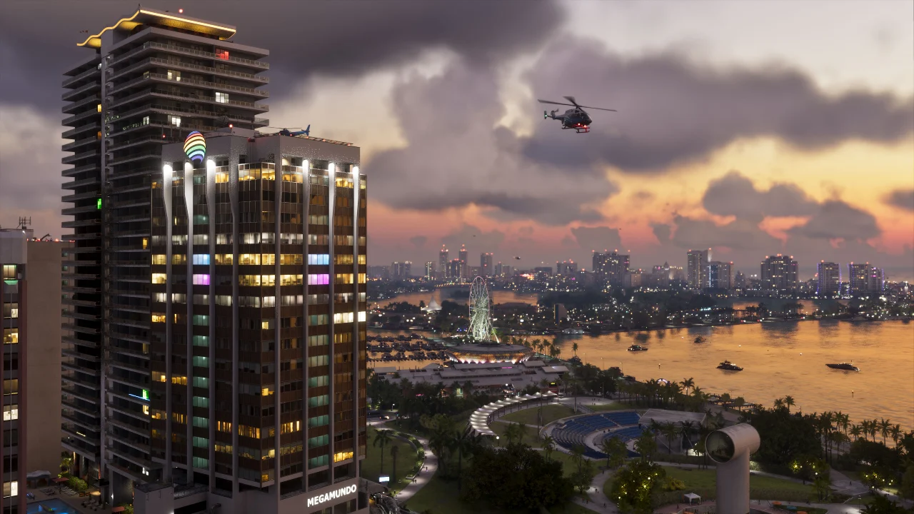 Helicopter above a waterfront skyline at sunset with illuminated buildings and boats